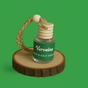 Mini diffuseur au parfum Verveine, présenté dans un petit flacon en verre transparent, avec une étiquette verte et un cordon torsadé, posé sur un rondin en bois avec un fond uni vert – création élégante Enzo & Caly fabriquée en France.