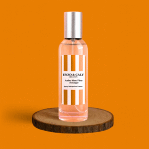 Spray au parfum d’ambiance Oud épicé, présenté dans une bouteille en verre transparent avec une étiquette bordeaux et blanche, posé sur un rondin en bois avec un fond uni bordeaux – création élégante Enzo & Caly fabriquée en France.