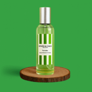 Spray au parfum d’ambiance Verveine, présenté dans une bouteille en verre transparent avec une étiquette verte et blanche, posé sur un rondin en bois avec un fond uni vert – création élégante Enzo & Caly fabriquée en France.